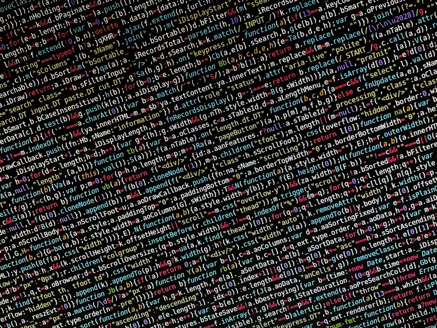 A close-up photograph of a computer monitor displaying lines of HTML code with text in various colors, including yellow, red, blue, and white. The screen shows tags such as <h1> and <div>, as well as 